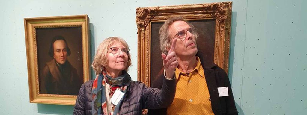 Mann und Frau bei Bildbetrachtung im Museum